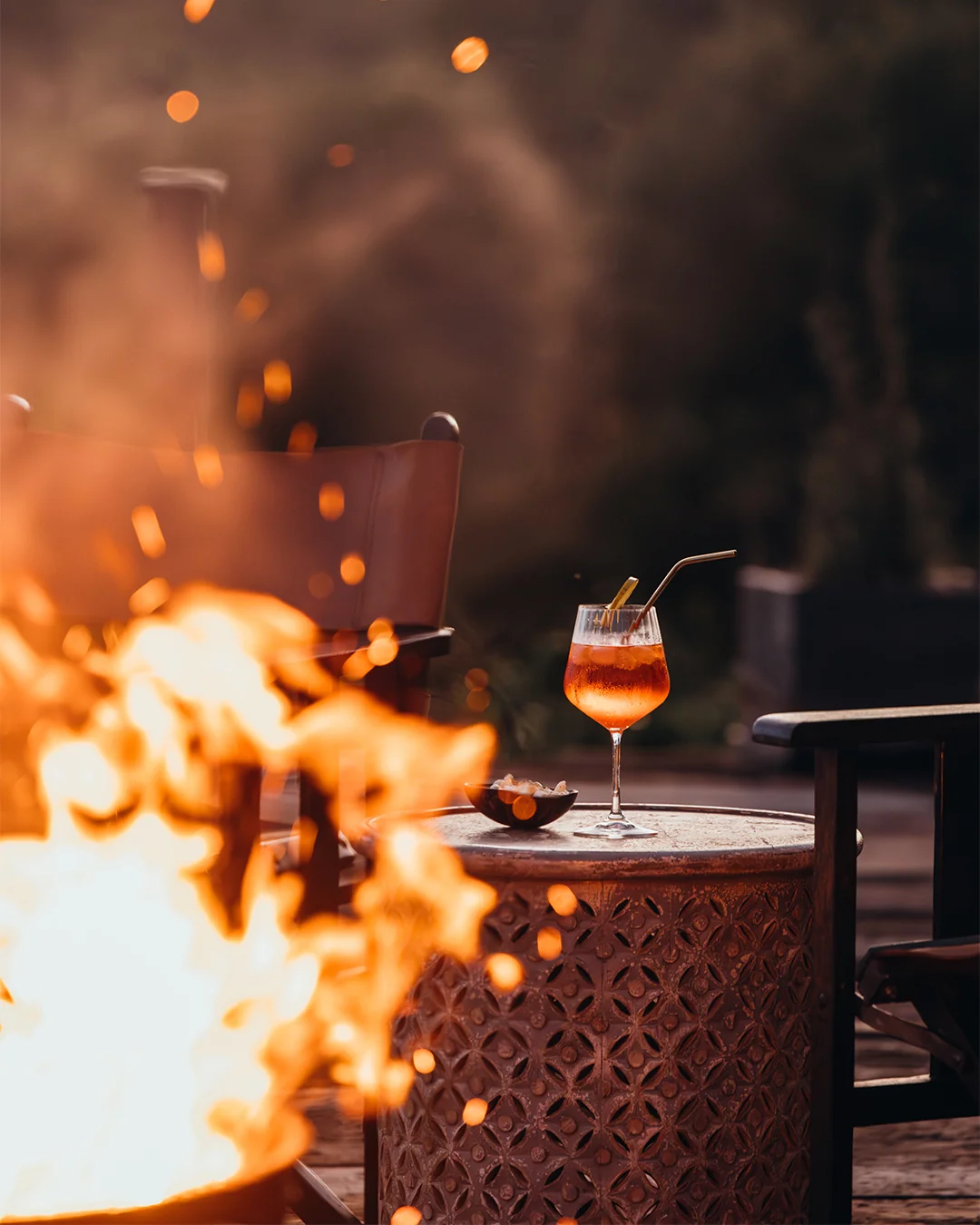 A cocktail beside a glowing safari fire