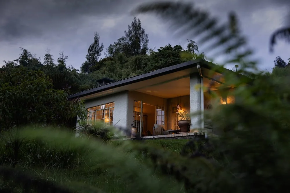 A guest cottage at Wilderness Sabyinyo Lodge at dusk